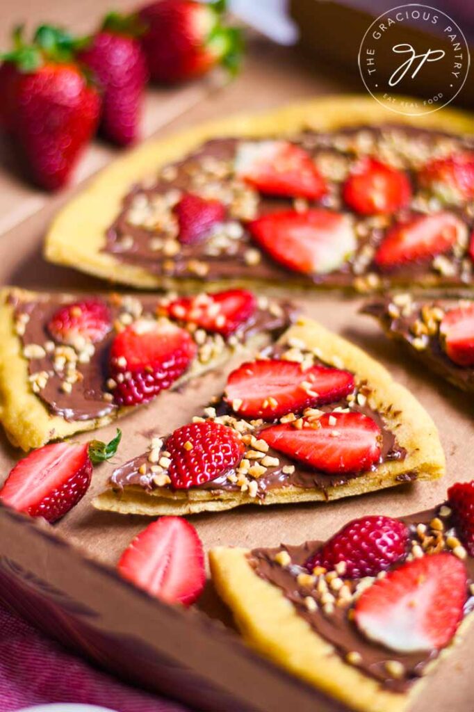 A chocolate pizza, sliced and sitting in a cardboard pizza box.