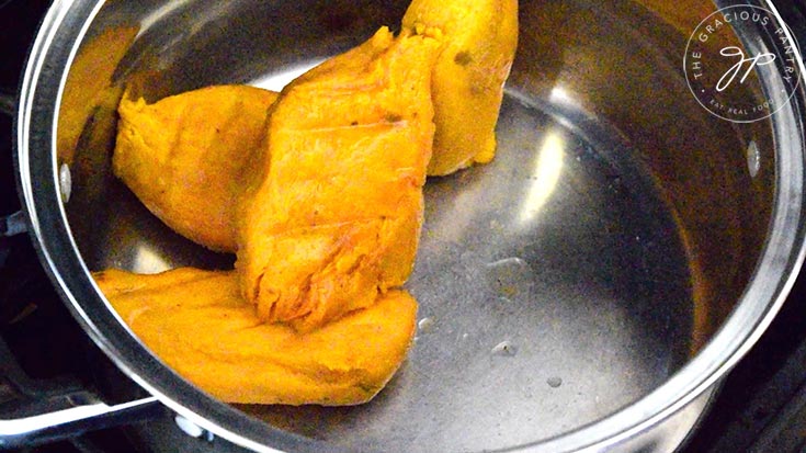 Cooked and peeled sweet potatoes sitting in a large soup pot.