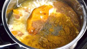 All the ingredients for Curried Sweet Potato Soup sitting in a large pot.