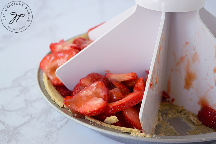 A pie slicer sitting in a fresh strawberry pie.