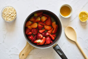 Chunks of strawberries sitting in a medium saucepot.