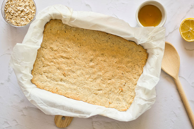 Cooked crust sitting in a parchment-lined baking pan.