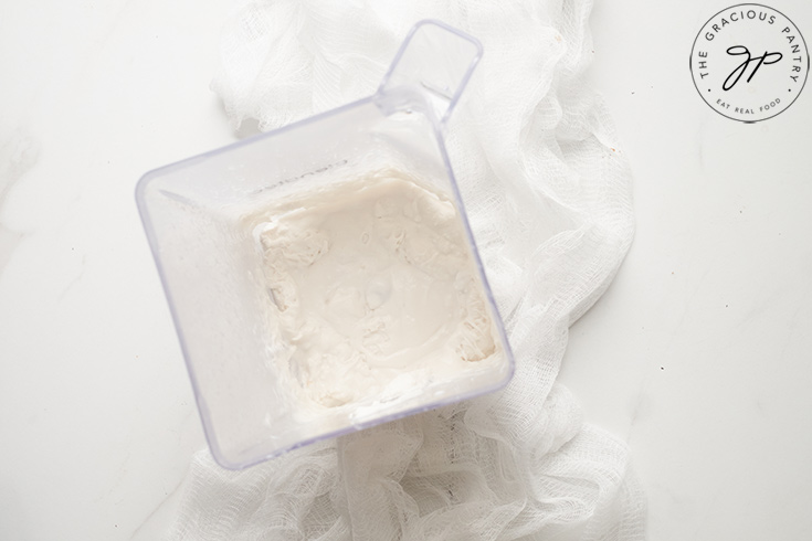 Partially frozen coconut milk sitting in a blender tumbler.