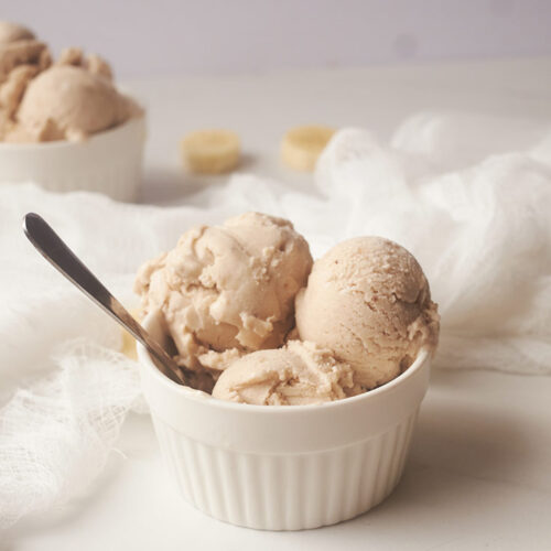 Three scoops of Coconut Banana Ice Cream in a white bowl.