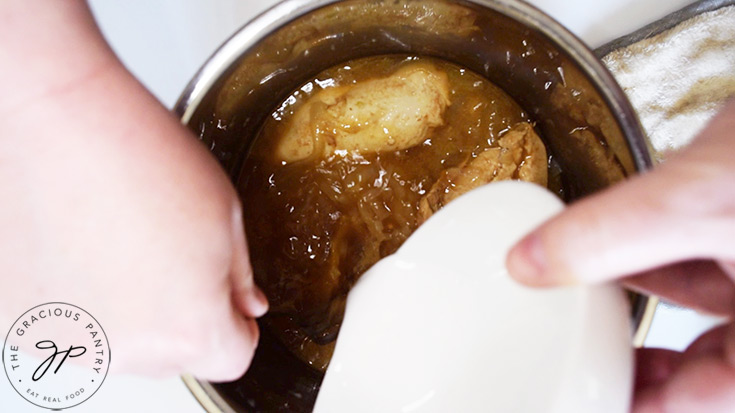 Stirring an arrowroot slurry into the finished french onion chicken in an Instant Pot.