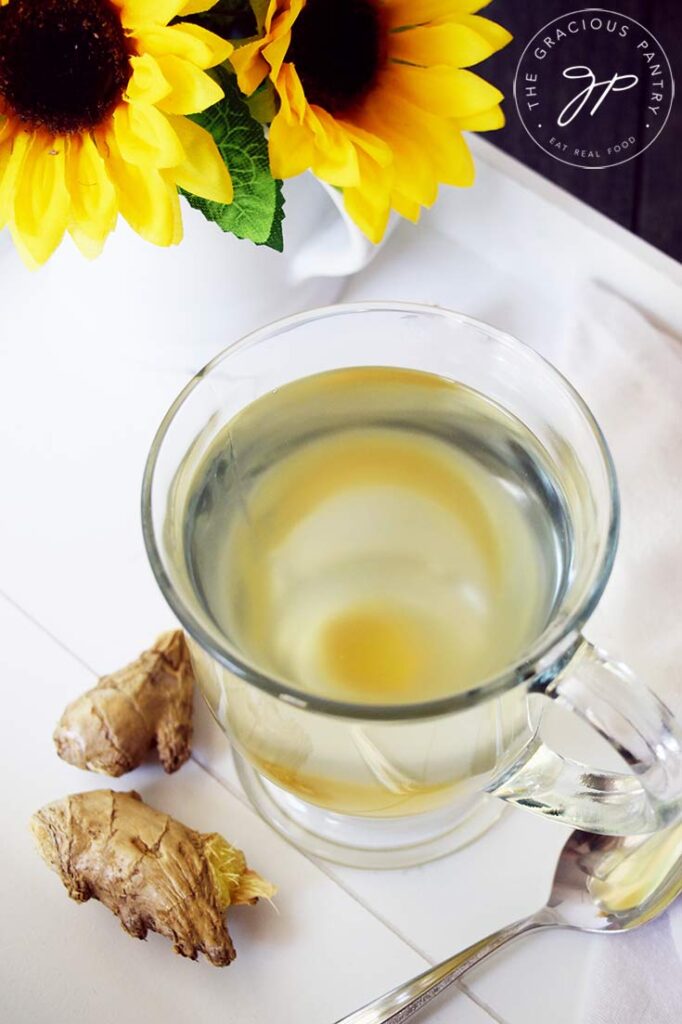 An overhead view looking down into a glass mug filled with Fresh Ginger Tea.