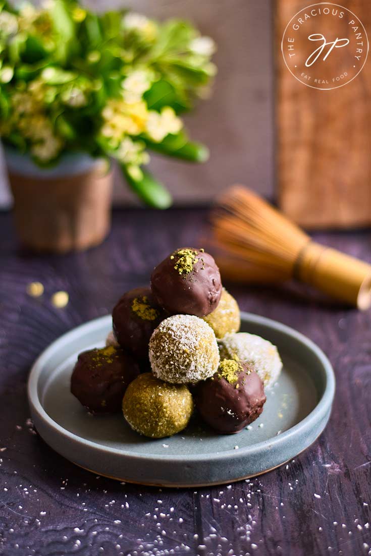 A stack of matcha energy balls stacked high on a gray plate.