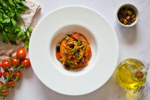 The finished Easy Pasta Puttanesca Recipe served in a white bowl with a wide rim.