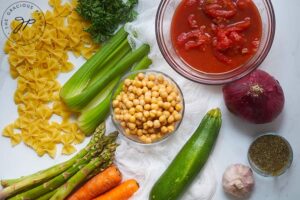 All the Bow Tie Pasta Salad Recipe ingredients on a white background.