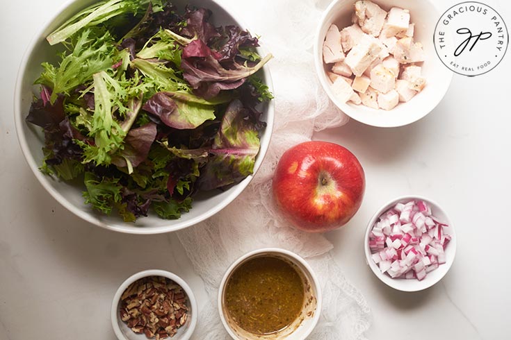 Salad recipe ingredients in white, individual bowls.