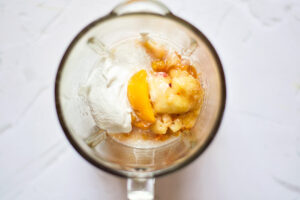 Homemade Peach Popsicles Recipe ingredients sitting in a blender tumbler.