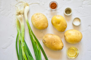 Accordion Potatoes Recipe ingredients gathered on a white surface.