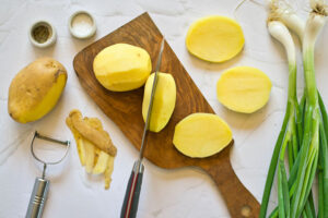 Cut potatoes on a cutting board.