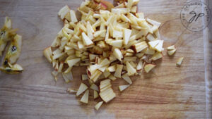 Chopped apples for apple salsa, sitting on a wooden cutting board.