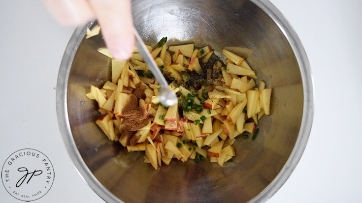 Adding ground black pepper to the apple salsa mix.