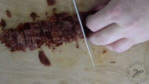 Cooked bacon being chopped.