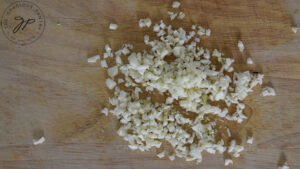 Minced garlic sitting on a cutting board.