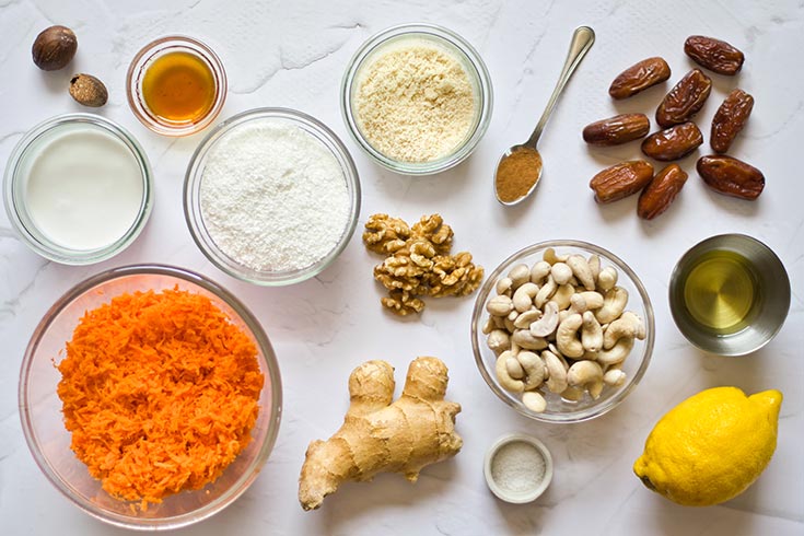 All the ingredients for this Gluten-Free Carrot Cake Recipe collected in individual bowls and sitting on a white surface.