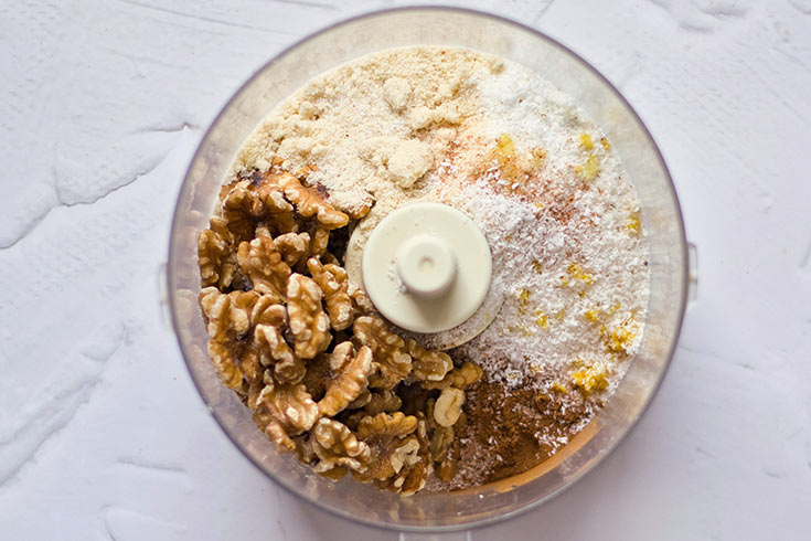 Carrot Cake crust ingredients sitting in a food processor bowl.