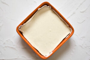 Topping spread over Gluten-Free Carrot Cake dough in a square baking dish.