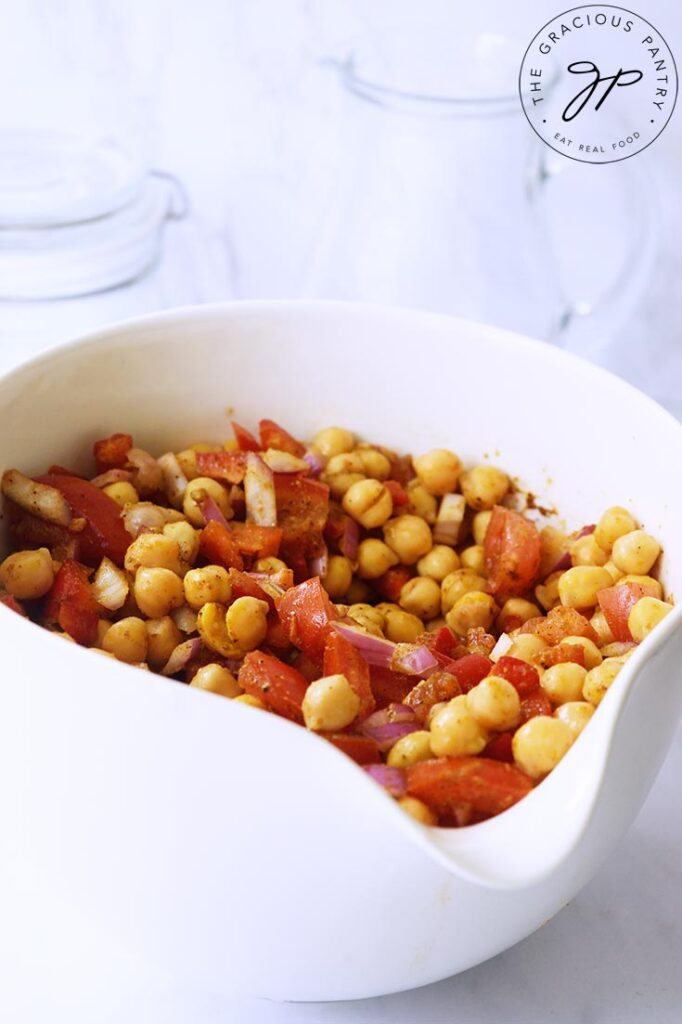 A front view of a white bowl filled with Indian Chickpea Salad.