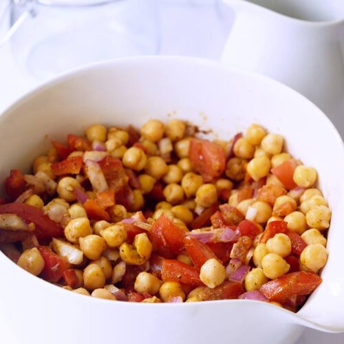 A side view of Indian Chickpea Salad in a white serving bowl.