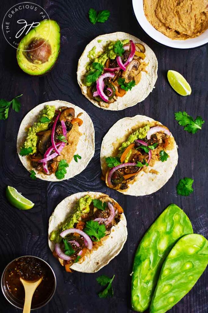 Prepared mushroom tacos laid out flat on a dark surface.