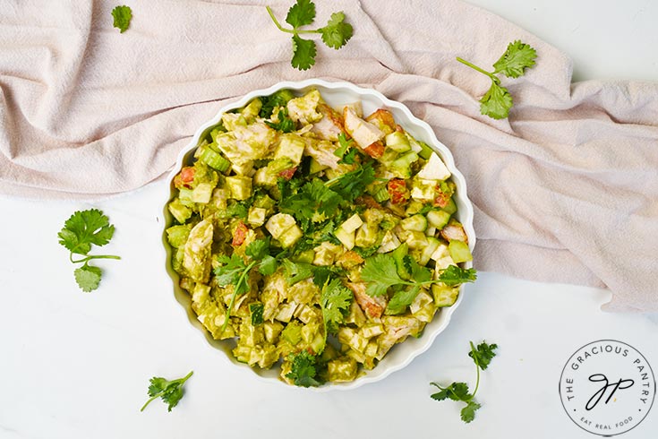 An overhead view of a white, fluted dish filled with chicken vegetable salad.