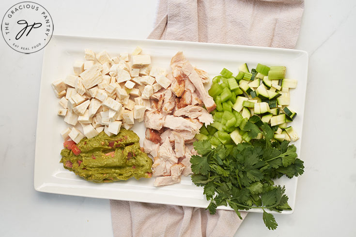 All the ingredients for this Chicken Vegetable Salad Recipe prepped and sitting on a white platter.