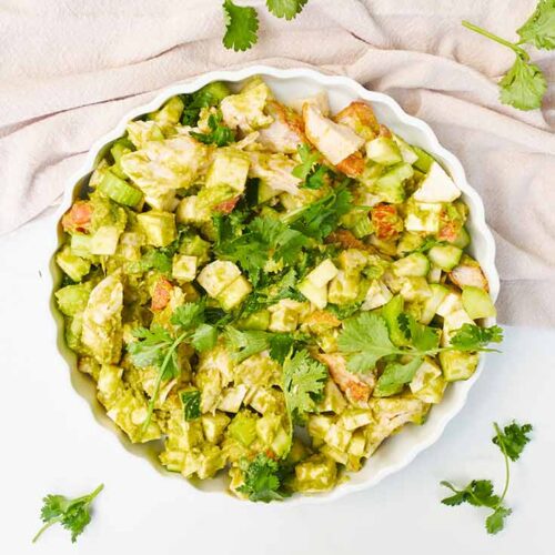 An overhead view looking down into a white, fluted plate filled with Chicken Vegetable Salad.