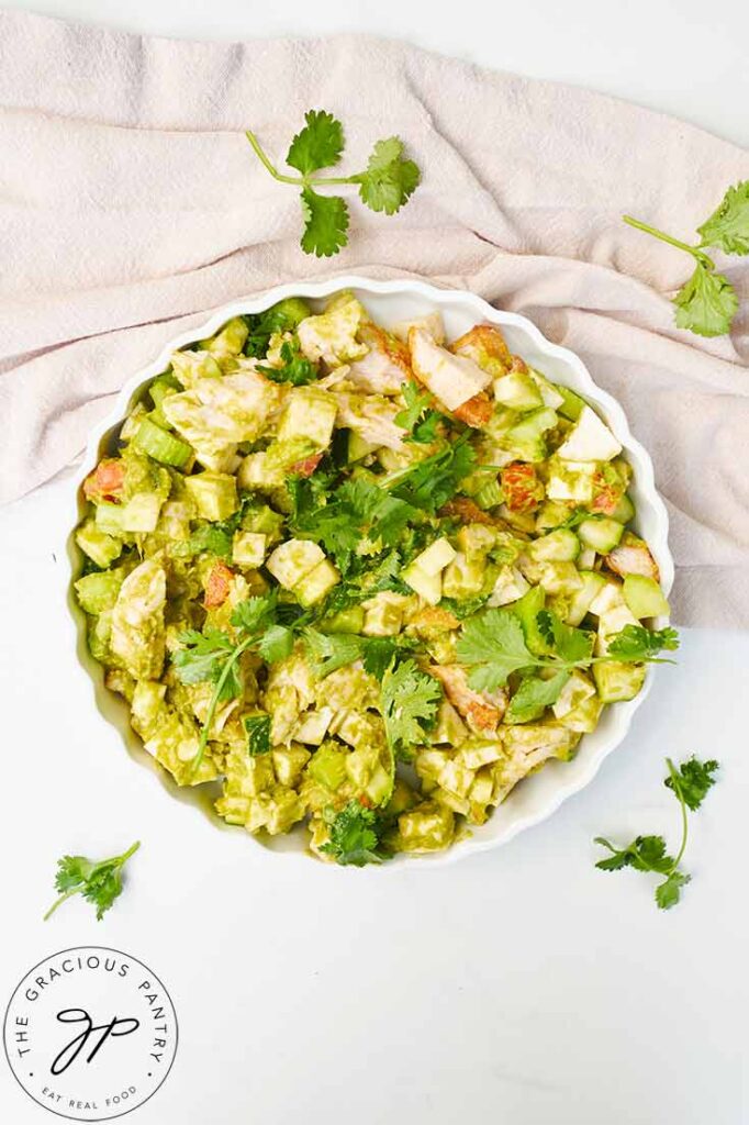 An overhead view looking down into a white, fluted plate filled with Chicken Vegetable Salad.