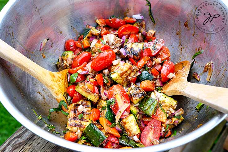 Just mixed Grilled Zucchini Salad sitting in the metal bowl it was mixed in.