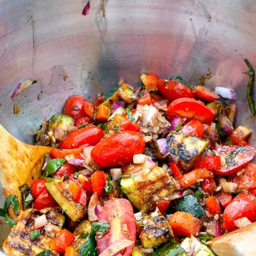 Grilled Zucchini Salad sitting in a the metal mixing bowl it was mixed in.