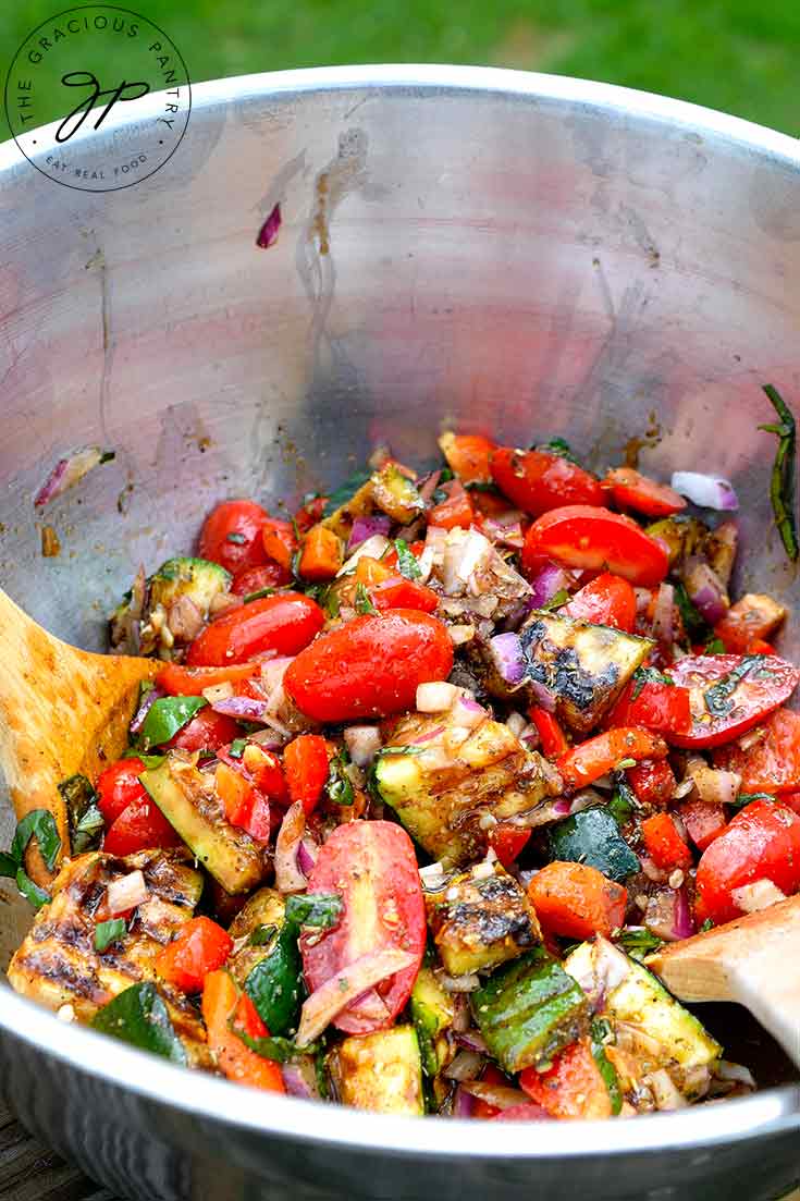 Grilled Zucchini Salad sitting in a the metal mixing bowl it was mixed in.