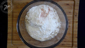 All the oat flour flatbread recipe ingredients sitting in a glass mixing bowl.