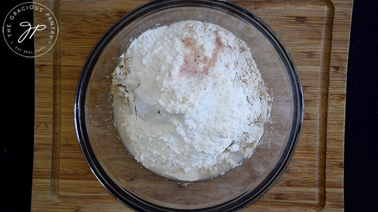 All the oat flour flatbread recipe ingredients sitting in a glass mixing bowl.