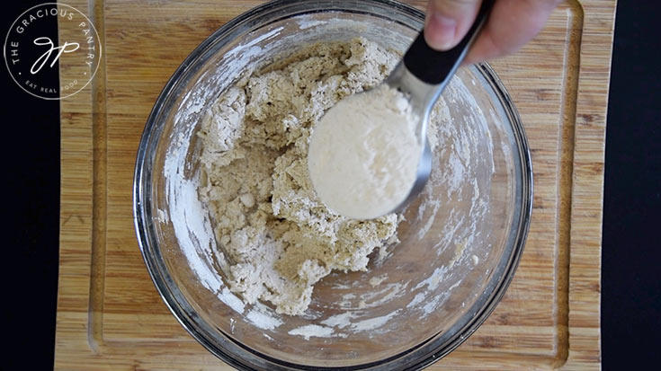 Adding more oat flour to the oat flour flatbread.
