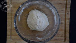 A ball of oat flour flatbread dough sitting in a glass mixing bowl.