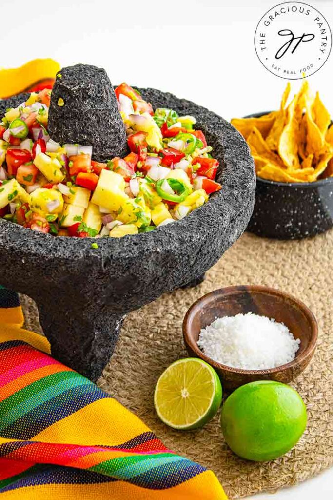 A side view of a stone salsa bowl holding pineapple salsa.