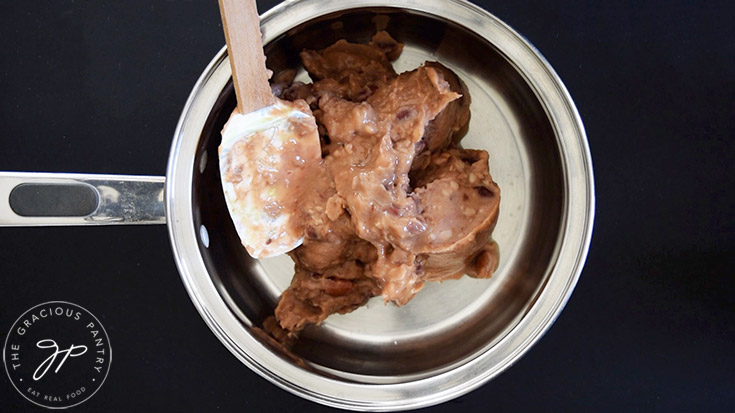 Canned refried beans in a pot.