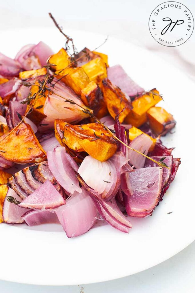 A side view of a white plate holding Herb And Garlic Roasted Sweet Potato Salad.