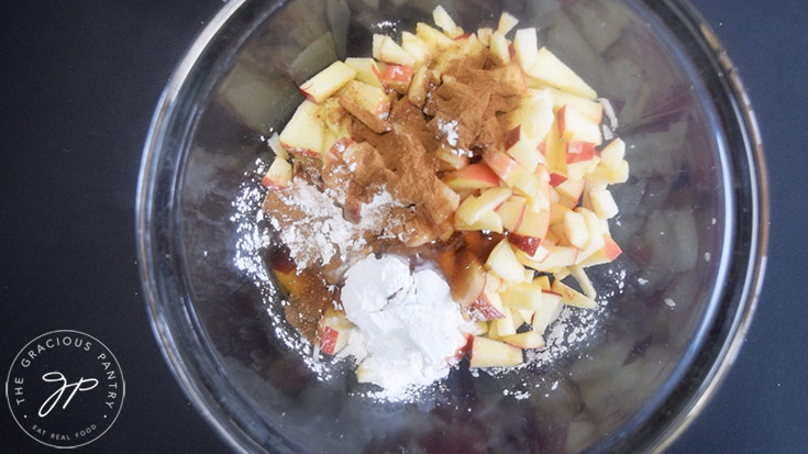 Apple Hand Pie filling ingredients in a glass mixing bowl.