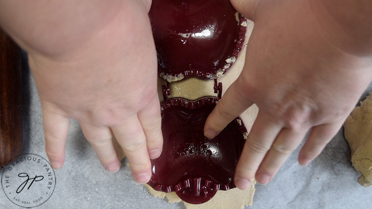 Pressing the hand pie form into the rolled out dough.