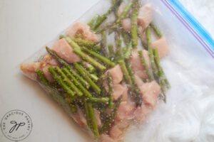 Chopped asparagus and chicken in a zipper-top, plastic bag.