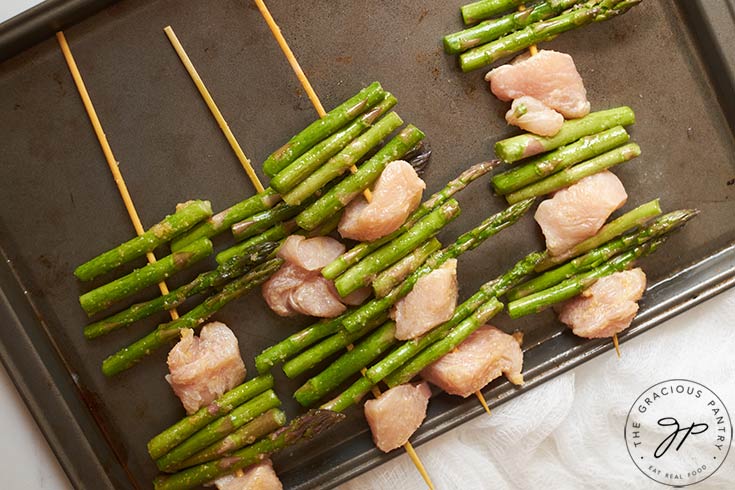 Kabobs laying on a sheet pan.