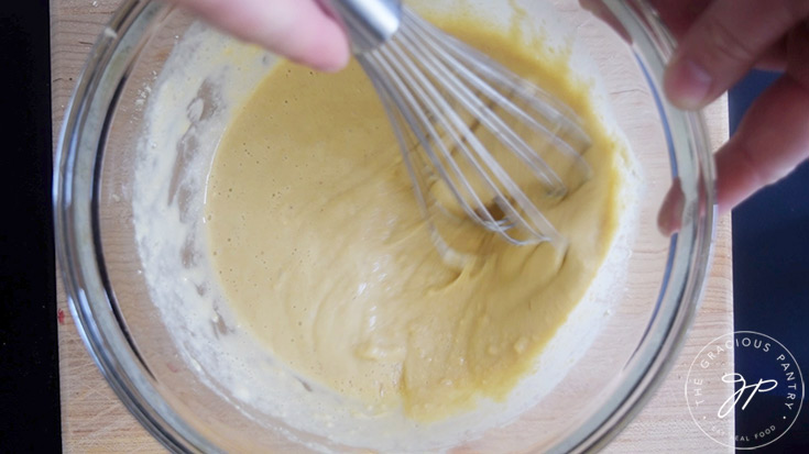 Chickpea Tofu batter being whisked in a glass mixing bowl.