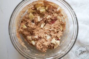 The mixed, raw Cinnamon Apple Muffin batter sitting in a mixing bowl.