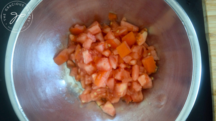 Chopped tomatoes in a mixing bowl for classic bruschetta.