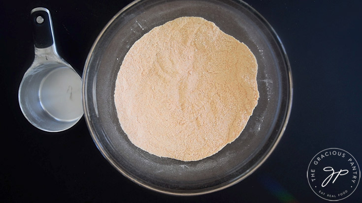 Red lentil flour, oat flour and salt whisked together in a glass mixing bowl.