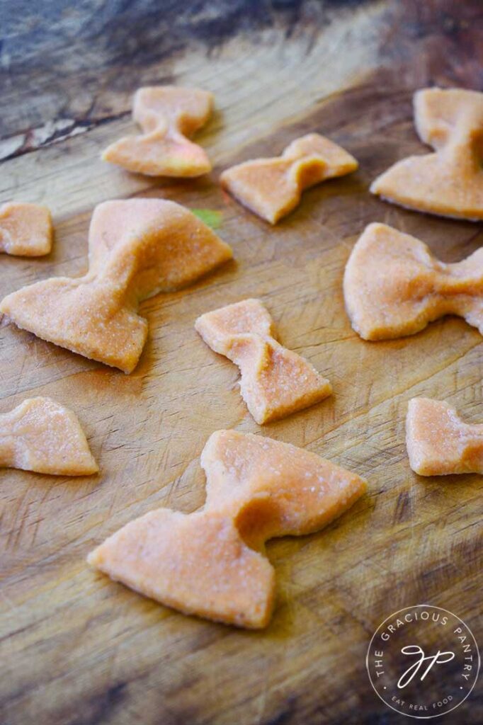 Bow Tie shaped Complete Protein Pasta laying on a wooden surface.